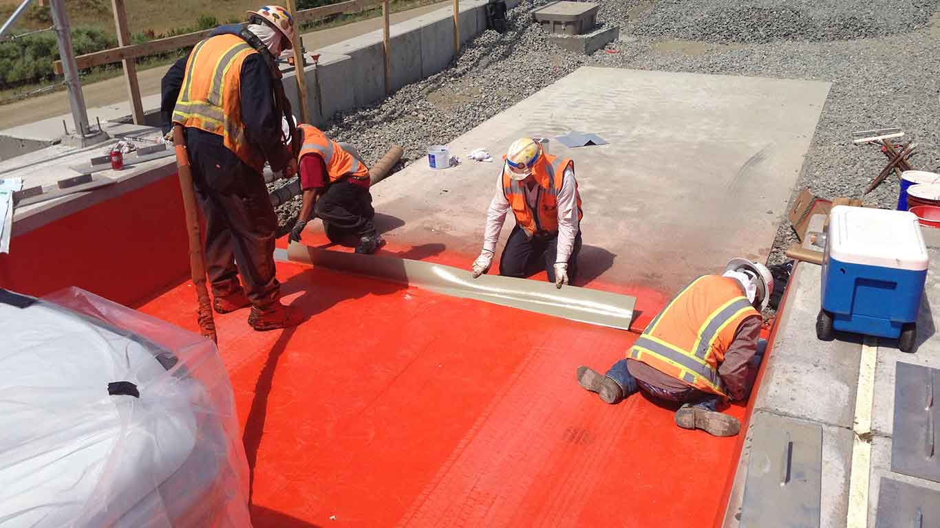 Railway bridge waterproofing application showing membrane installation process with ASFI Construction crew