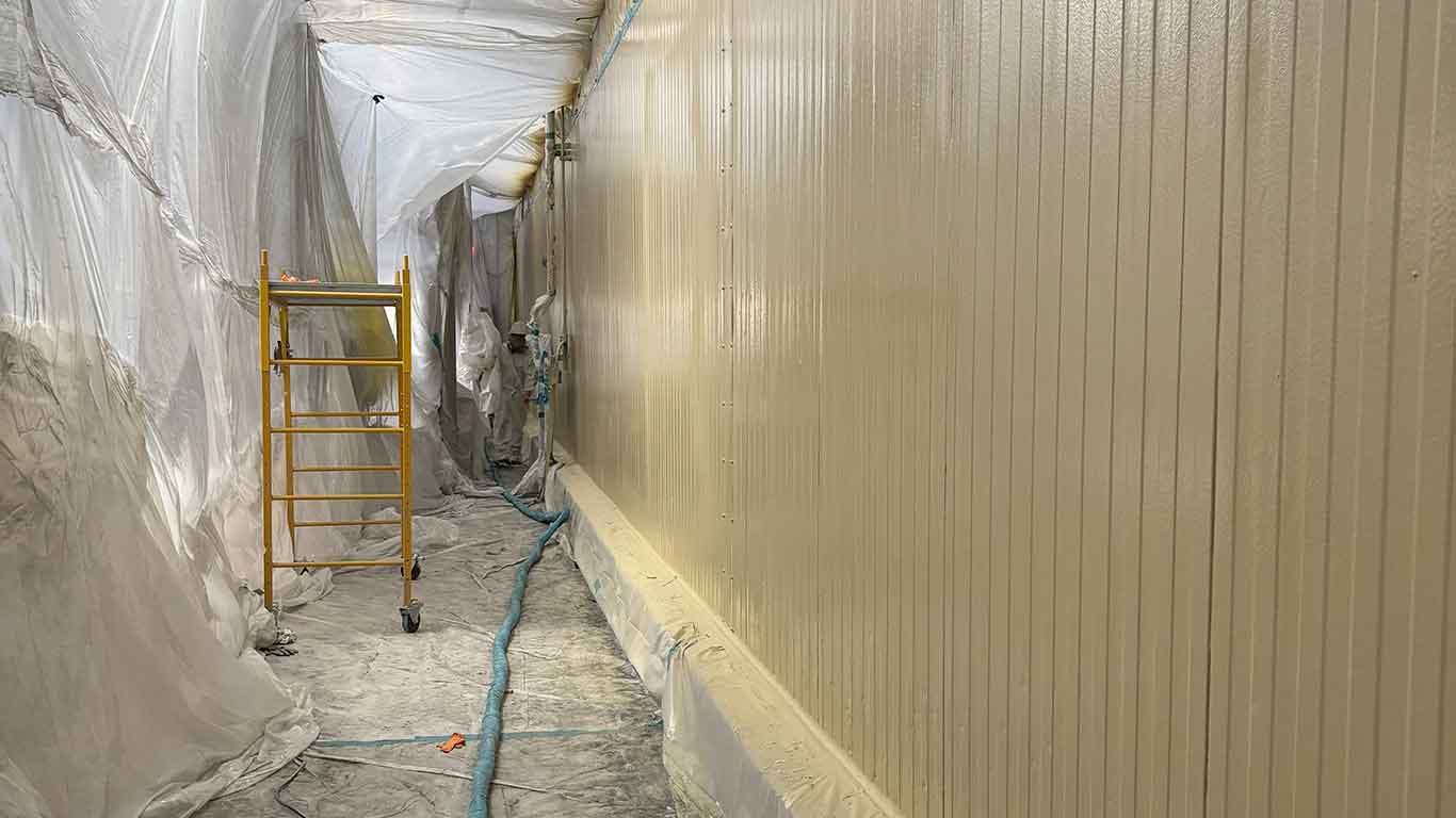 Food processing plant interior with bright white polyurea coating on walls and ceiling, showing clean industrial environment